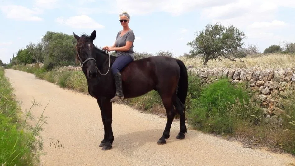 Nicki reitet Lucero auf einem Feldweg